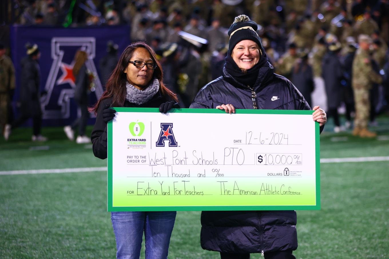 Tricia Brandenburg presenting a check to the West Point Schools PTO as part of the Extra Yard for Teachers campaign. 