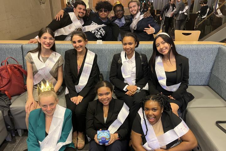 students sit and pose with their awards