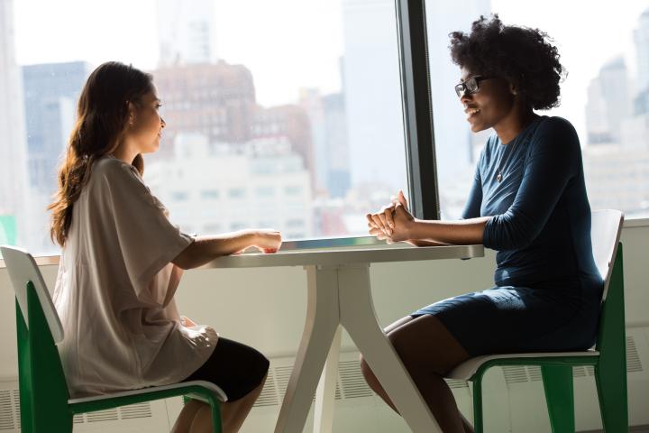 two people sitting at a table in a job interview