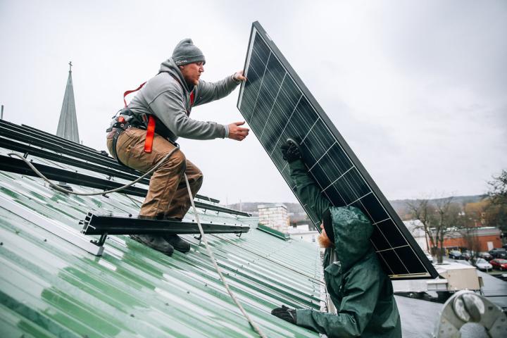 Two workers installing solar panels